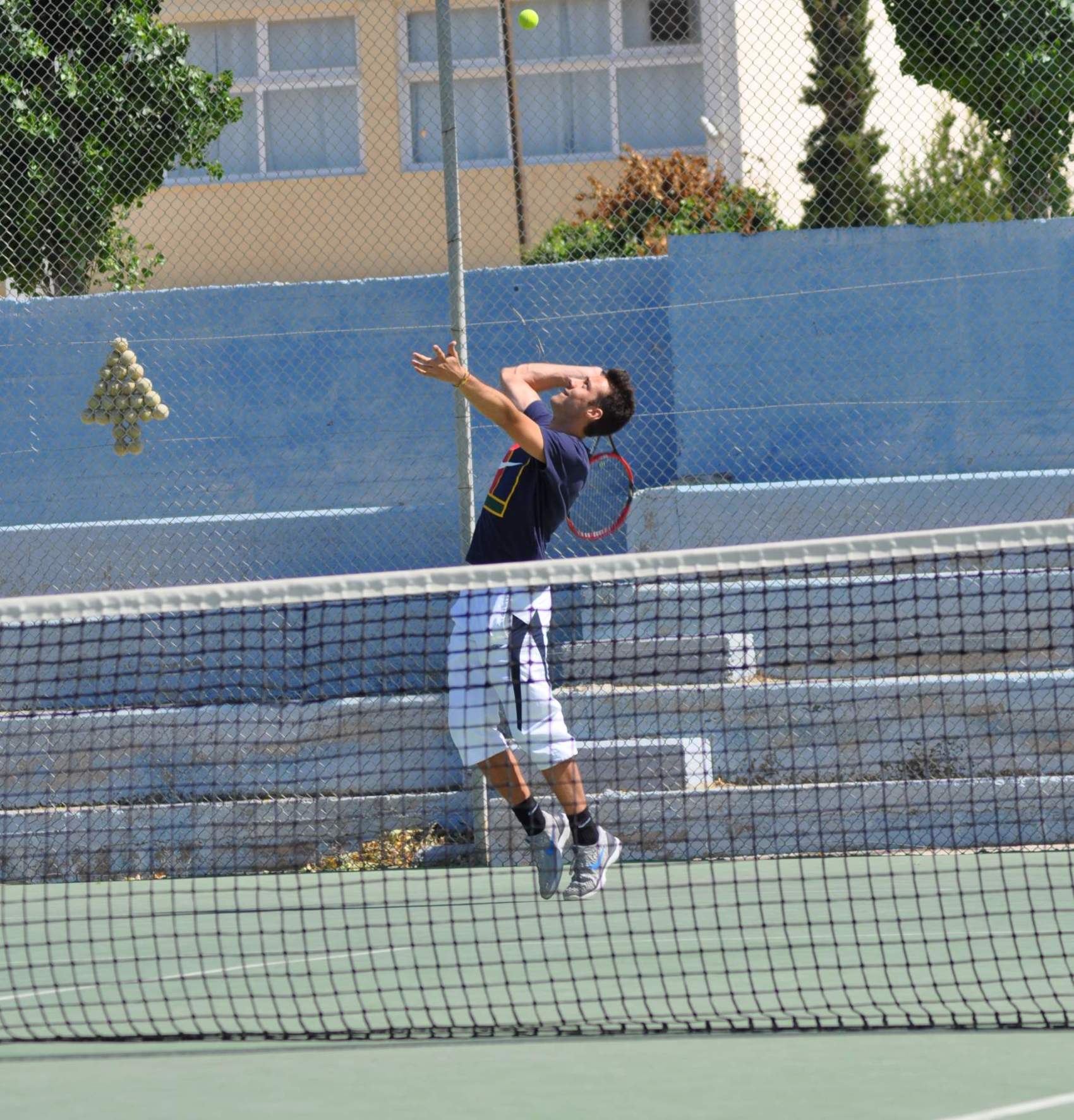 The tennis coach from Tennis in Crete hitting a serve.