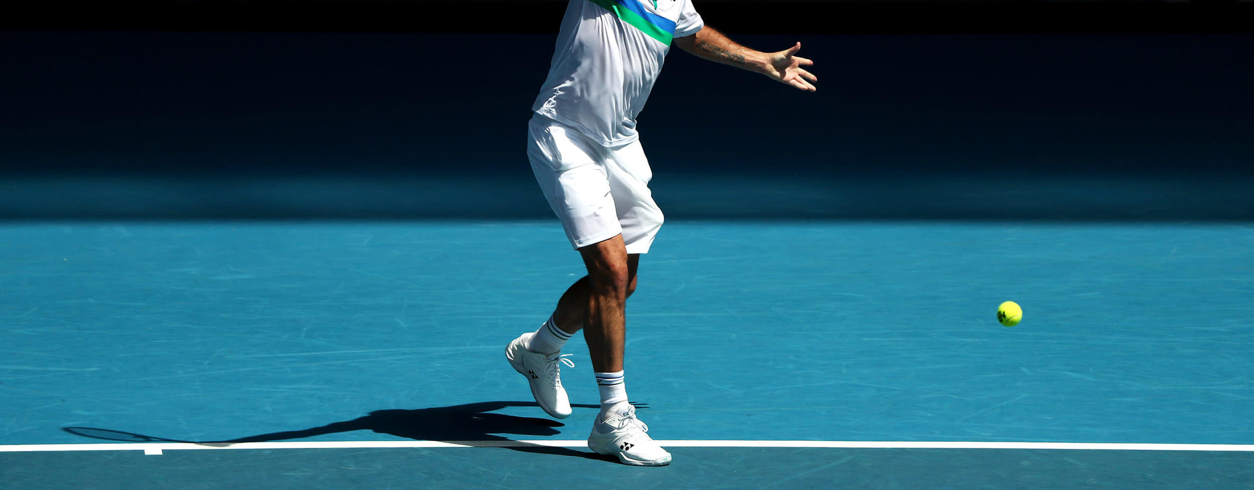 Tennisspieler bei der Vorbereitung einer einhändigen Rückhand während eines Tennistrainings.